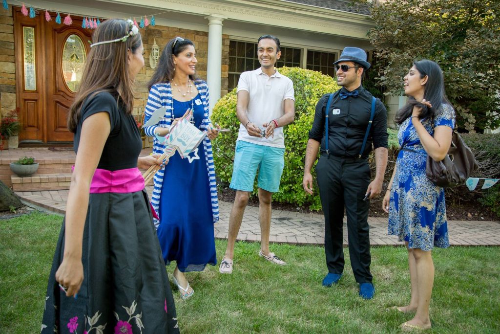 5 people smiling in a yard during a gender reveal party
