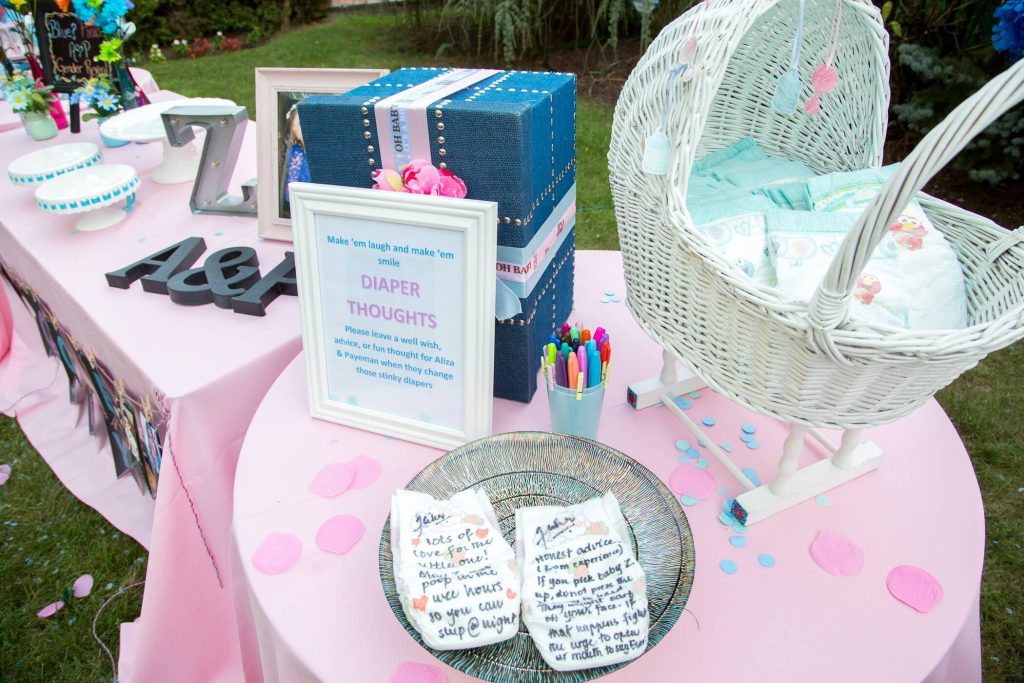 baby basket with playful diaper messages on a gender reveal table