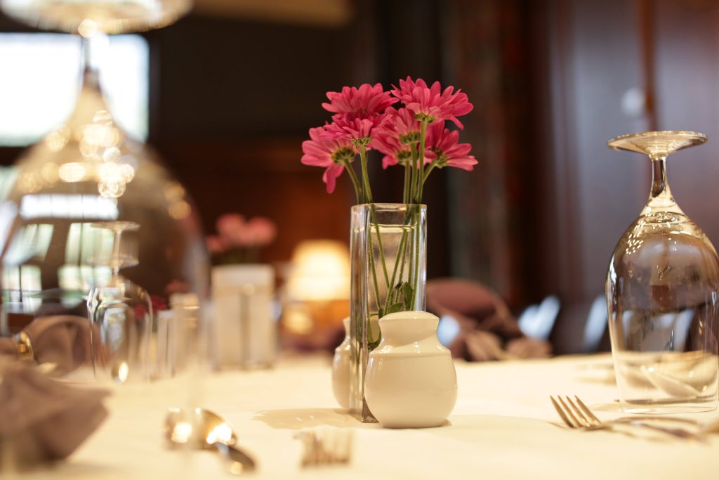 table setting with large clear glasses and a small flower arrangement in the center