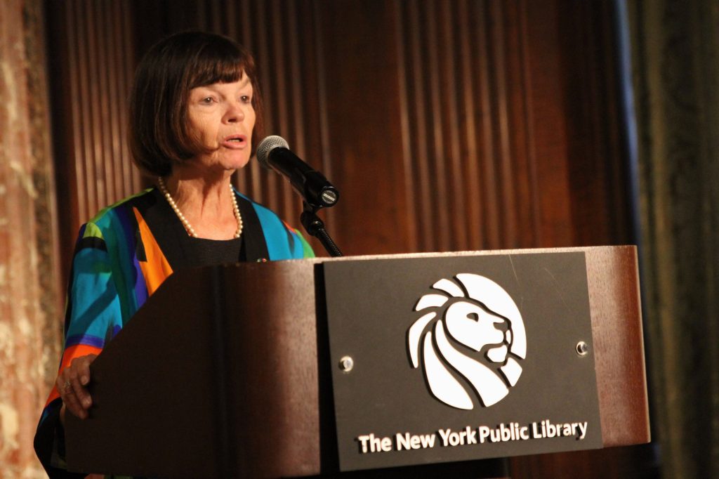 female public speaker with short brown hair at a podium for the New York Public Library
